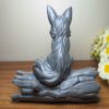 Декоративная фигурка сидящей лисы на дереве — очаровательная скульптура дикой природы